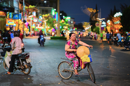 Can Tho, Vietnam - February 27, 2016: Street with people on bicycle and motorcycles in Can Tho, Vietnam, at nightのeditorial素材