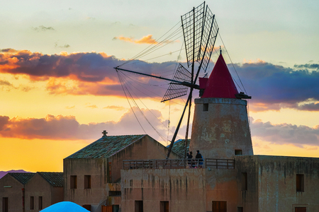 Sunset at Windmill in the salt evoporation pond of Marsala, Sicily island, Italyの写真素材