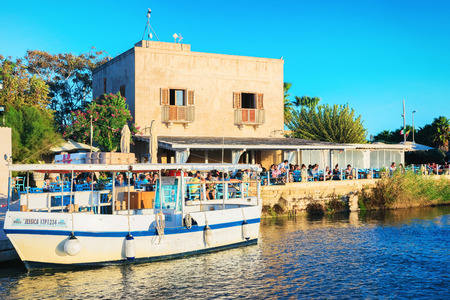 Marsala, Italy - September 19, 2017: Ship and people in street cafe at the salt evaporation pond in Marsala, Sicily island, Italyのeditorial素材