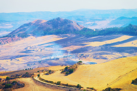Landscape of valley with fires in fields in Enna province, Sicily of Italyの写真素材