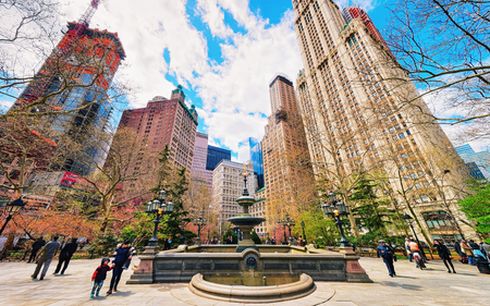 New York, USA - April 24, 2015: Fountain at City Hall Park with tourists in Lower Manhattan, New York, NYC, USA. Skyscrapers on the background.のeditorial素材
