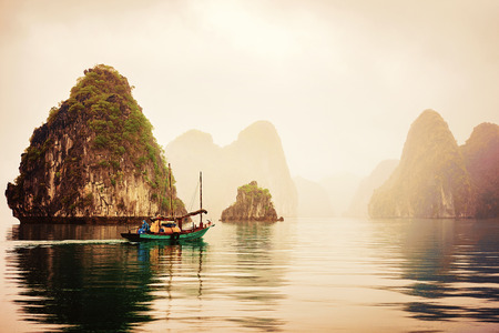 Halong, Vietnam - February 23, 2016: Fishing boat, Ha Long Bay, Vietnam at sunset. Limestone islands on the backgroundのeditorial素材
