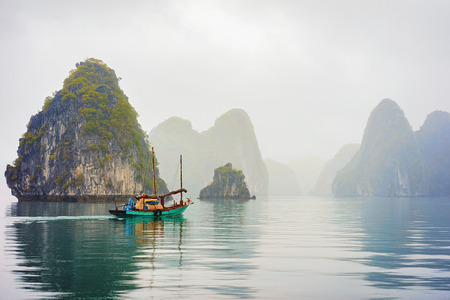 Halong, Vietnam - February 23, 2016: Fishing boat, Ha Long Bay, Vietnam, Asia, at sunset. Limestone islands on the backgroundのeditorial素材
