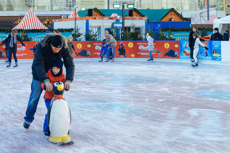 Berlin, Germany - December 10, 2017: Family on Ice Skating rink on Christmas Market at Alexanderplatz in Winter Berlin, Germany. Advent Fair Decoration and Stalls with Crafts Items on the Bazaar.のeditorial素材