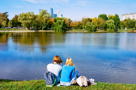 Young girls sitting at Park at Novodevichy Pond looking at Moscow City skyscrapers in Moscow in Russiaのeditorial素材