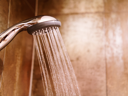 Shower head with the running water in a bathの写真素材