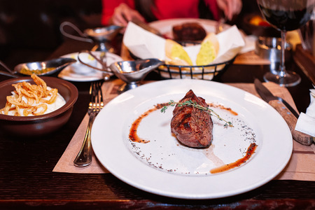 Medium rare Steak with pepper sauce on the white plate in a restaurantの写真素材