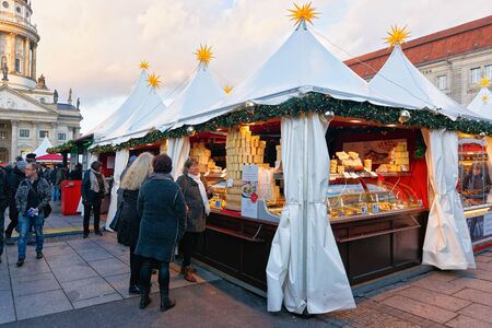 Berlin, Germany - December 8, 2017: People at food Stalls at Night Christmas Market on Gendarmenmarkt in Winter Berlin of Germany. Advent Fair Decoration and Crafts Items on the Bazaar.のeditorial素材