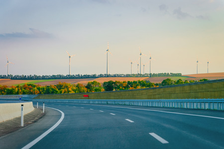 Scenic landscape with the road in Slovenia. Wind mills on the background.