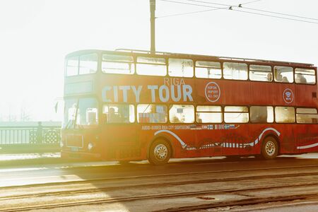 Riga, Latvia - December 27, 2017: Excursion red touristic bus in the streets of the Old city of Riga, Latvia.のeditorial素材