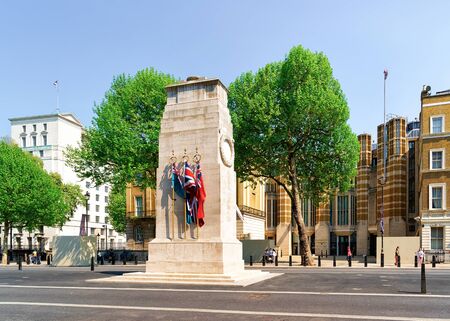 London, UK - April 30, 2011: Cenotaph War Memorial with flags on Whitehall on downtown street in London in the UK. Square with green trees in England, British capital of United Kingdom.のeditorial素材