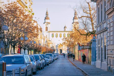 Ljubljana, Slovenia - January 15, 2019: Cars parked in Street and cityscape on St Peter Church in Ljubljana old town, Slovenia, Europe. People in Slovenian city view in winter.のeditorial素材