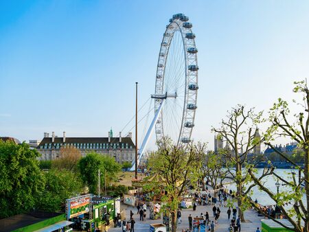 London, UK - April 30, 2011: People at Victoria Embankment and London Eye Ferris Wheel and County Hall at Thames River in London city in UK. Westminster Palace and Big Ben Parliament in England.のeditorial素材
