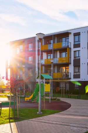 Vilnius, Lithuania - October 9, 2018: Apartment residential house facade architecture and kid playground and outdoor facilities. Blue sky on the background. With sun lightのeditorial素材