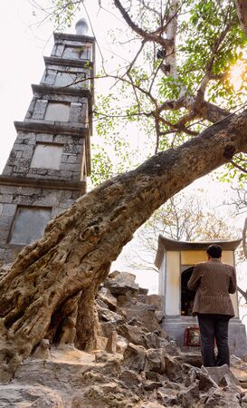 Man praying at Ngoc Son Temple of Jade Mountain on West Lake in Hanoi, capital of Vietnam in Southeast Asia. Person at Traditional tower gate architecture. Male prayerの写真素材