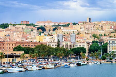 Cityscape with Old city and Sardinian marina with ships at Mediterranean Sea in Cagliari, South Sardinia Island in Italy in summer. View on town port with Yachts and boatsの写真素材