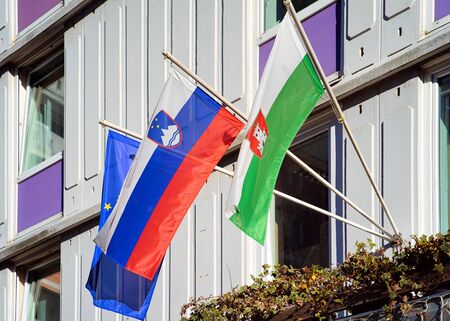 Slovenian flag, Ljubljana flag and EU flag on building in Ljubljana old town streets, Slovenia in evening. Slovenian city view in spring. Landmark. Urban green capital.の写真素材