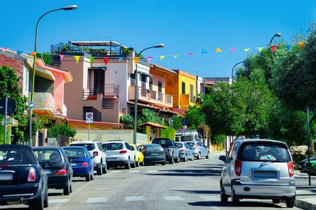 Street view with cars parked in the Road in town in province of Cagliari in Sardinia Island in Italy. Cityscape with building architecture.の写真素材