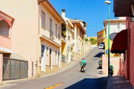Street view with Scooter on Road in town in province of Cagliari in Sardinia Island in Italy. Cityscape with building architecture.の写真素材