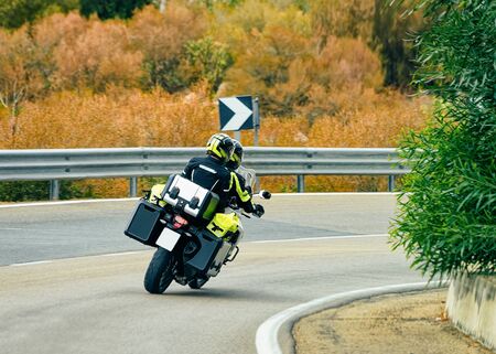 Motorcycle in the road at Costa Smeralda in Sardinia Island in Italy in summer. Motorcyclist driving scooter on the highway in Europe. View on moped on motorway.の写真素材