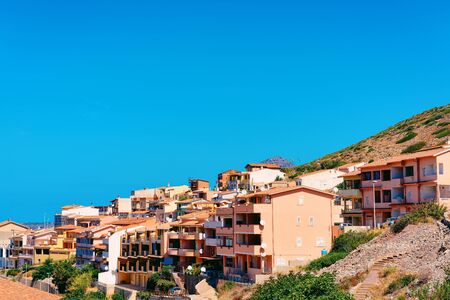 Buggerru city with houses architecture at the hills of the Mediterranean Sea in South Sardinia in Italy. Sardinian Italian small town with buildings in Sardegna.の写真素材