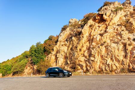 Car and the road in Costa Smeralda in Sardinia Island in Italy in summer. Transport driving on the highway in Europe. View on motorway. Hills and mountains on the backgroundの写真素材