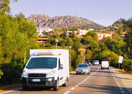 Rv cavaran and cars on the road in Sardinia Island in Italy in summer. Motorhome rving on motorway....