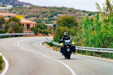 Motorcycle on the road in Sardinia Island in Italy in summer. Motorcyclist driving scooter on the highway in Europe. View on moped on motorway.の写真素材