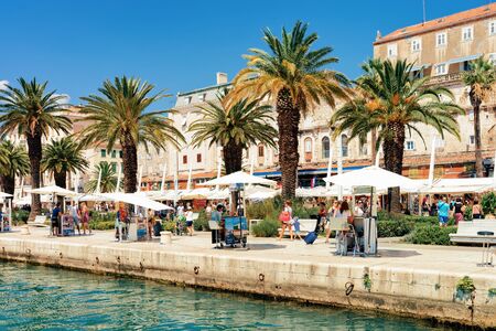 Split, Croatia - August 16, 2016: Tourists under Palm trees at Old city of Split on Adriatic Coast in Dalmatia in Croatia. People at Roman Town architecture at Croatian Dalmatian Bayのeditorial素材