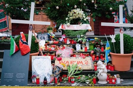 Berlin, Germany - December 11, 2017: Candles and flowers and sign with german word Warum, in English Why, at Christmas Market of Berlin, one year after terrorist attack.のeditorial素材