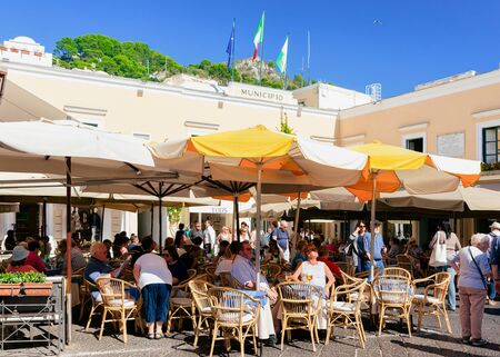 Capri, Italy - October 3, 2017: People in Street cafe and restaurant with table and chair, Capri Island, Naples, Italy. Cityscape with tourists at Cafeteria, Italian coast. Anacapri in Amalfiのeditorial素材