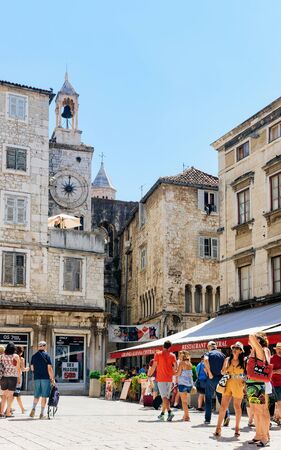 Split, Croatia - August 16, 2016: Tourists on Square with Famous clock tower in Old city of Split on Adriatic Coast in Dalmatia in Croatia. Roman architecture and people in Dalmatian Town.のeditorial素材