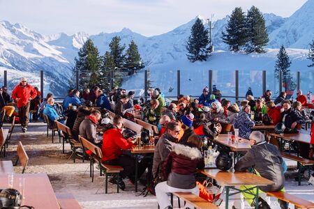 Mayrhofen, Austria - February 6, 2019: People in street cafes with tables in Penken ski resort in Zillertal in Tyrol. Austria in winter in Alps. Tourists eating and drinking in restaurants, Mayrhofenのeditorial素材