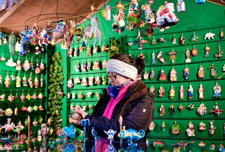 Berlin, Germany - December 9, 2017: Seller at Stall in Christmas market in Charlottenburg in Berlin in Germany in Europe in winter. German Night street Xmas and holiday fairのeditorial素材