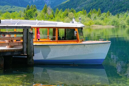 Touristic tour boat on Bohinj Lake in Slovenia. Nature and Cruise ship on river water in Slovenija. Beautiful landscape nature view in summer. Alpine Travel destination. Julian Alps mountainsの写真素材