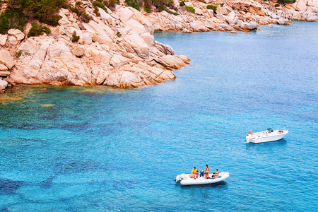 Boats on the Mediterranian Sea near mountains in Capo Testa in Santa Teresa Gallura, Sardinia, Italy. Ship and blue water.のeditorial素材