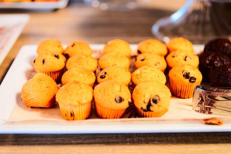 Sweet muffin pastry with chocolate and blueberries in cafe and bakery. Puff mini cakes at patisserie. Food for breakfast. Fresh baked buns for desert. Gourmet and cuisine. Homemade quick breadの写真素材
