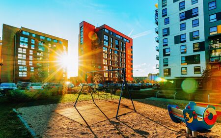 Modern residential apartment and flat building exterior and outdoor playground facility. New luxury house and home complex and green yard. City Real estate property and condo architectureの写真素材