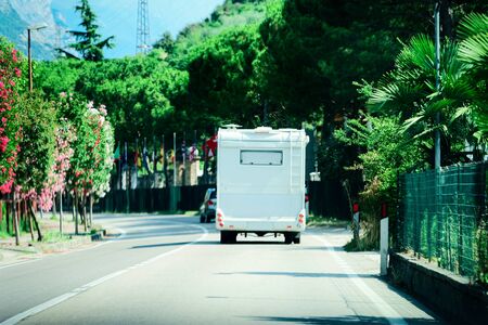 Landscape with rw caravan on road at town on Garda Lake in Trentino in Italy. Scenery with motor...