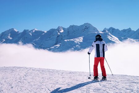 Man Skier skiing in Zillertal Arena ski resort in Tyrol in Mayrhofen, Austria, winter Alps. Alpine mountains with white snow and blue sky. Downhill fun at Austrian snowy slopes.の写真素材