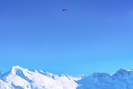 Chopper above Peaks of Hintertuxer Gletscher in Alpine mountainsの写真素材