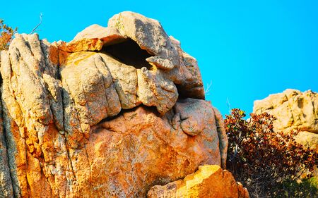 Rural landscape with hills and highland. Mountains in form of head with nose and eyes. Panorama in Sardinia island at Italy. Scenery of Sardegna, summer. Olbia province. Mixed media.の写真素材