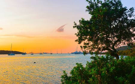 Sunrise or sunset with yachts at Porto Rotondo on Costa Smeralda at Mediterranean sea in Sardinia island of Italy. Boat in Sardegna in summer. Landscape of Olbia province. Mixed media.の写真素材
