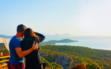 Scenery with couple at Porto Rotondo at sunrise or sunset at Mediterranean Sea on Costa Smeralda. People and Porto Cervo, Sardinia Island in Italy in summer. Landscape of Olbia province. Mixed media.の写真素材