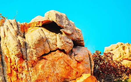 Rural landscape with hills and highland of Costa Smeralda. Mountains in form of head with nose and eyes. Panorama in Sardinia island at Italy. Scenery of Sardegna, summer. Olbia province. Mixed media.の写真素材
