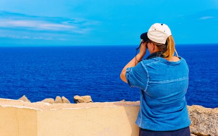 Woman and Landscape with Rocky coast of Capo Testa in Santa Teresa Gallura at the Mediterranean Sea on Sardinia Island in Summer Italy. Girl and Scenery of Cagliari province. Mixed media.の写真素材