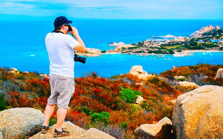 Man and Landscape with Rocky coast of Capo Testa in Santa Teresa Gallura at the Mediterranean Sea on Sardinia Island in Summer Italy. Scenery of Cagliari province. Mixed media.の写真素材