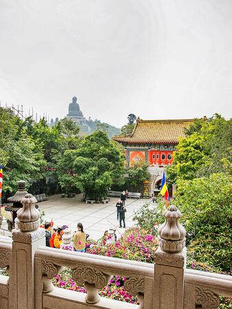 Hong Kong, Hong Kong - January 11, 2012: Big Buddha statue at Ngong Ping and Po Lin Monastery on Lantau Island in Hong Kong. People on the background. Mixed media.のeditorial素材