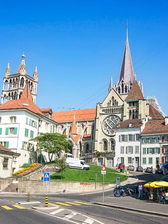 LAUSANNE, SWITZERLAND - AUGUST 23, 2013: Lausanne Cathedral (Notre Dame) in summer street view. Mixed media.のeditorial素材