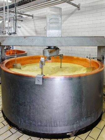 Evillers, France - August 31, 2016: Processing of Gruyere de Comte Cheese in the dairy in Franche Comte, Burgundy, in France. Mixed media.のeditorial素材
